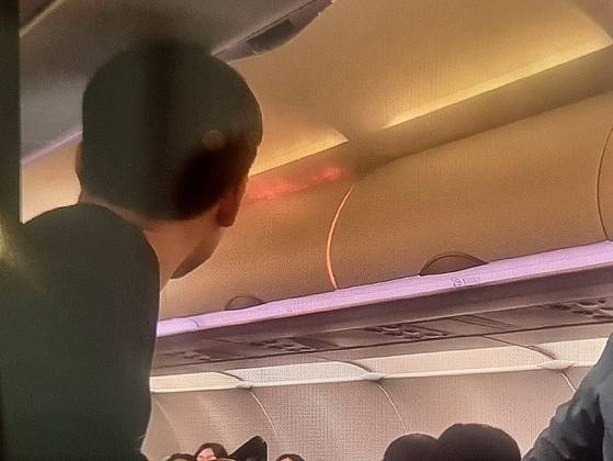 Flames erupt from the overhead compartment inside Air Busan flight BX391, bound for Hong Kong, on Jan. 28, in this photo provided by a reader. [NEWS1]