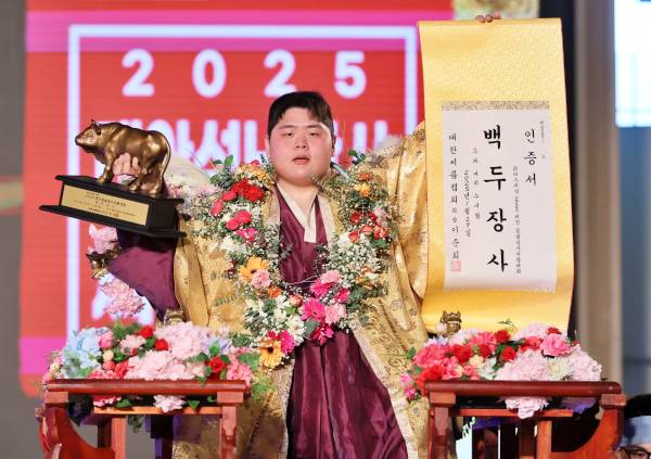 김민재가 29일 충남 태안군 태안종합실내체육관에서 열린 ‘위더스제약 2025 태안설날장사씨름대회’에서 백두장사(140kg 이하)에 등극한 후 장사꽃가마에 올라 장사인증서와 황소트로피를 들고 기념사진을 찍고 있다. 대한씨름협회 제공