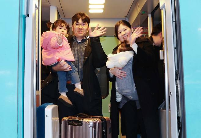 설 연휴를 하루 앞둔 24일 서울 용산역에서 한 가족이 고향으로 가는 귀성열차에서 취재진을 향해 손을 흔들고 있다./이솔 기자
