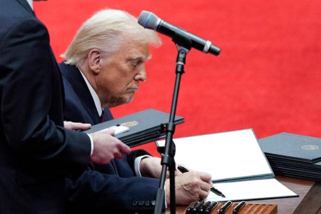 도널드 트럼프 미국 대통령이 1월 20일(현지시간) 워싱턴 캐피털 원 아레나에서 열린 실내 대통령 취임 퍼레이드 행사 중 행정 명령에 서명하고 있다. 워싱턴=AP 뉴시스