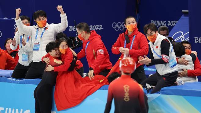 ビクターアンドテクノロジーコーチ（Ahn Hyun -Soo、2番目に左）は、中国のプレーヤーが2022年に中国の北京で開催された冬季オリンピックショートトラックの男子1000mファイナルで優勝したときに応援しています。ニュース1