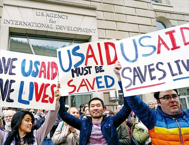 < “국제개발처 지키자” 시위 나선 시민들 >  3일(현지시간) 미국 워싱턴DC에 있는 국제개발처(USAID) 본부 건물 앞에서 시민들이 ‘USAID는 반드시 지켜져야 한다’는 뜻을 담은 팻말을 들고 시위하고 있다.  로이터연합뉴스
