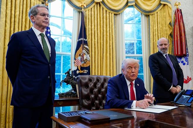 도널드 트럼프 미국 대통령이 3일(현지시간) 워싱턴DC 백악관 집무실에서 스콧 베센트 재무장관(왼쪽), 하워드 러트닉 상무장관 지명자(오른쪽)가 지켜보는 가운데 행정명령에 서명하고 있다. 트럼프 대통령은 이날 미 연방정부 국부펀드 설립을 지시했다. /로이터=뉴스1