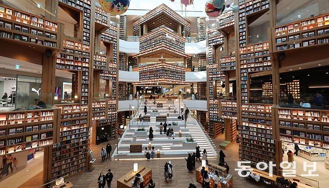 디지털과 인공지능(AI)으로 대표되는 현대 사회에서 사물 본연의 감각을 온몸으로 느끼고 싶어 하는 이들도 많다. 모바일로 전자책을 손쉽게 볼 수 있는 시대지만 종이책에 이끌린 사람들은 도서관을 찾는다. 스타필드 수원점에 마련된 별마당 도서관. 동아일보 DB