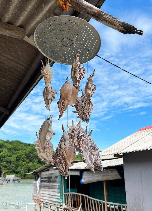 빈탄섬 수상가옥 처마에 소라껍질 장식이 걸려 있다.