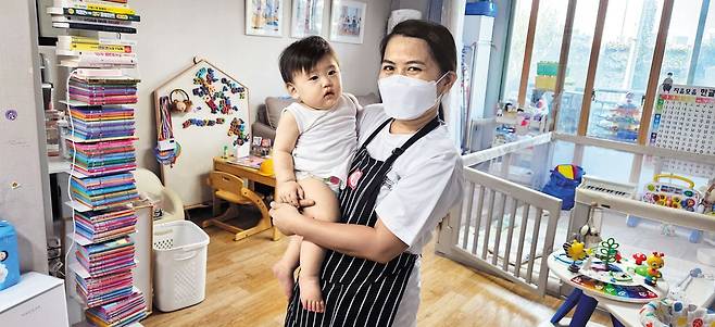 지난해 9월부터 서울의 185가정에서 아이를 돌봐온 필리핀 가사관리사 98명의 근무 지속 여부가 불확실해졌다. 이달 말 시범 사업 기간이 종료되는데, 사업이 계속될지 정해지지 않았기 때문이다. 사진은 서울의 한 가정에서 아이를 안고 있는 필리핀 가사관리사. /서울시