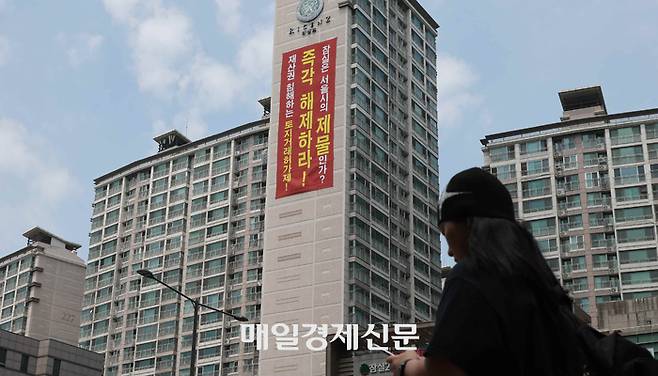 잠실 엘스·리센츠 아파트 외벽에 토지거래허가제 해제를 요구하는 현수막이 걸려있다. [이승환 기자]