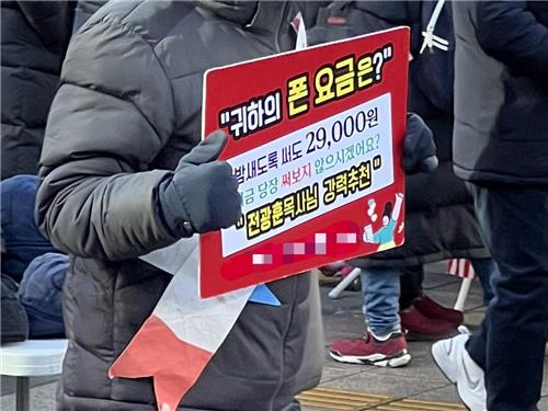 지난 8일 윤석열 대통령 탄핵 반대 집회에서 ‘퍼스트모바일’을 판촉하는 남성. [사진 출처 = 연합뉴스]
