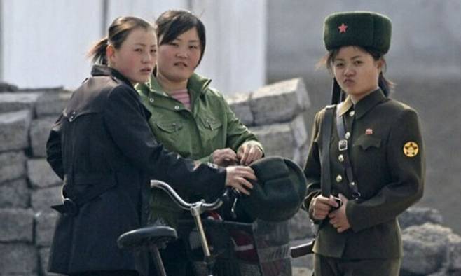 2010년 4월25일 북한 신의주 근처 압록강 기슭에서 북한 여군과 민간인이 서&nbsp;있는 모습. 로이터연합뉴스