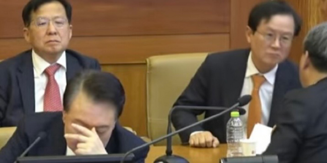 11일 서울 종로구 헌법재판소에서 열린 탄핵심판 7차 변론에 출석한 윤석열 대통령이 머리를 감싸 쥔 채 생각에 잠긴 듯한 모습을 보이고 있다. (SBS 캡처)