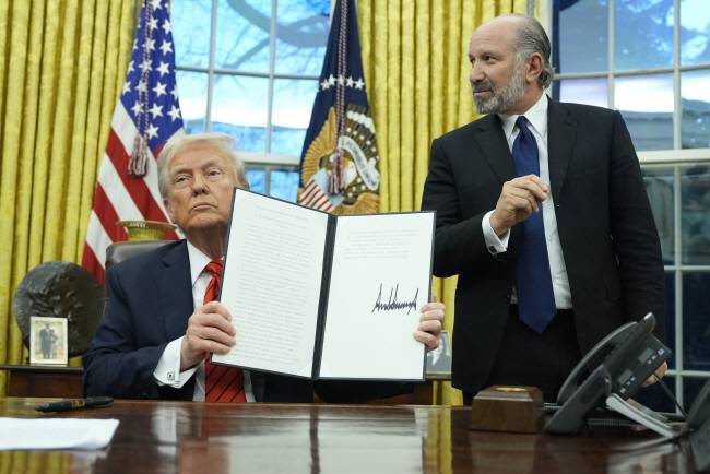 “철강 25% 관세, 모든 국가 적용”    10일 도널드 트럼프(왼쪽) 미국 대통령이 백악관 집무실에서 미국에 수입되는 철강과 알루미늄 제품에 25%의 추가 관세를 부과한다는 내용의 행정명령에 서명한 뒤 들어 보이고 있다.  AP 연합뉴스