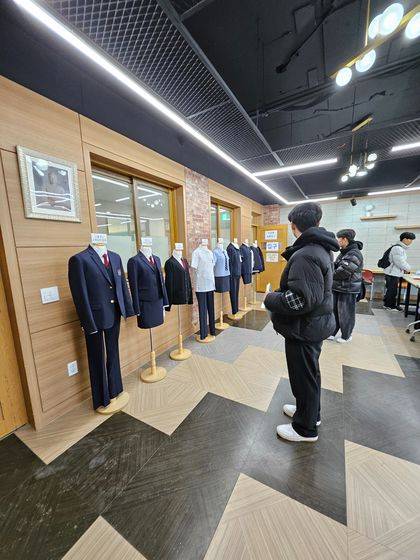 Incoming boy students take a look at their new school uniforms at a high school run by Dongguk University. The school is set to transition from girls-only to coed starting from the spring semester. [GARAM HIGH SCHOOL]