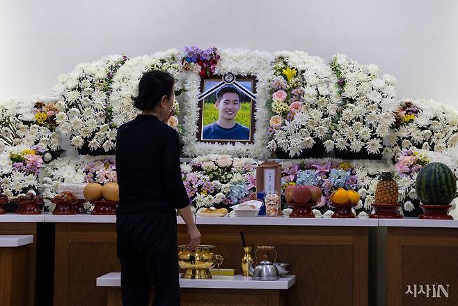 2024년 12월30일 HD현대미포 조선소에서 수중 작업을 하다 목숨을 잃은 김기범씨의 영정을 그의 할머니가 바라보고 있다. ⓒ시사IN 신선영