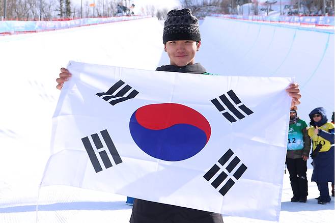 13일 중국 야부리 스키리조트에서 열린 하얼빈 동계아시안게임 스노보드 남자 하프파이프 결선에서 금메달을 차지한 김건희가 태극기를 들고 미소를 짓고 있다. 사진 | 야부리=연합뉴스
