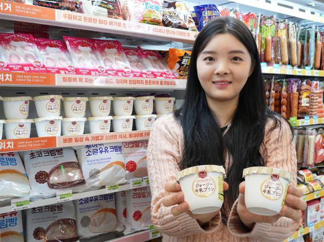 편의점 세븐일레븐 직원이 일본에서 직소싱한 '오하요 저지푸딩'을 들고 있다. 세븐일레븐 제공