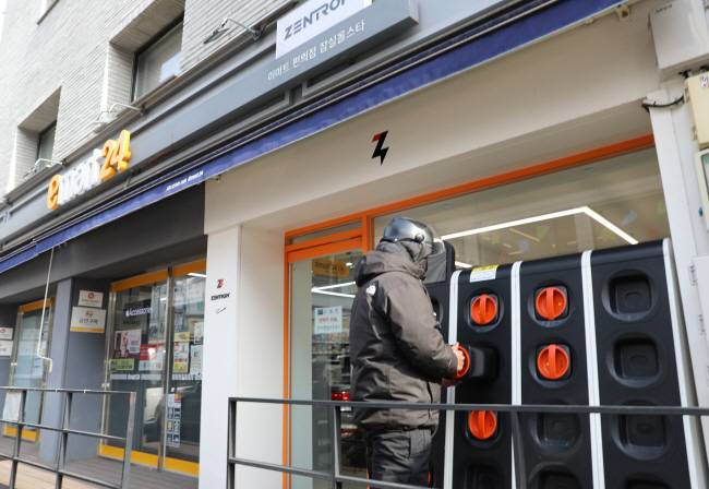 지난 6일 서울 송파구 이마트24 잠실올스타점에서 한 배달 라이더가 전기 이륜차 배터리를 교환하고 있다.  이마트24 제공