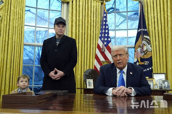 [워싱턴=AP/뉴시스] 일론 머스크가 11일(현지 시간) 워싱턴DC 백악관 대통령 집무실에서 트럼프 대통령의 발언을 듣고 있다. 왼쪽은 머스크 아들 엑스 애쉬 에이 트웰브(X Æ A-Xii), 오른쪽은 도널드 트럼프 미국 대통령. 2025.02.12.