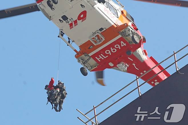 14일 부산 기장군 반얀트리 호텔 신축 공사장에서 화재가 발생해 소방대원들이 헬기를 동원해 옥상으로 대피한 인부를 구조하고 있다. 2025.2.14/뉴스1 ⓒ News1 윤일지 기자