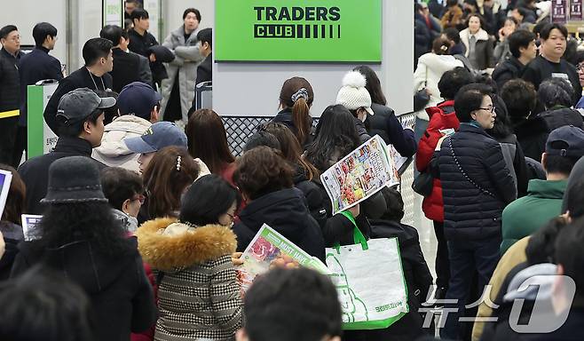 14일 오전 서울 강서구 트레이더스 홀 세일 클럽(이하 트레이더스) 마곡점을 찾은 고객들이 매장 개장 시간 전에 입장을 위해 줄지어 서서 행사 전단을 살펴보고 있다. 트레이더스 마곡점은 지난 2023년 12월 오픈한 수원화서점에 이어 14개월만에 오픈하는 점포로, 월계점에 이어 서울특별시에 2번째로 선보이는 점포다. 2025.2.14/뉴스1 ⓒ News1 김진환 기자