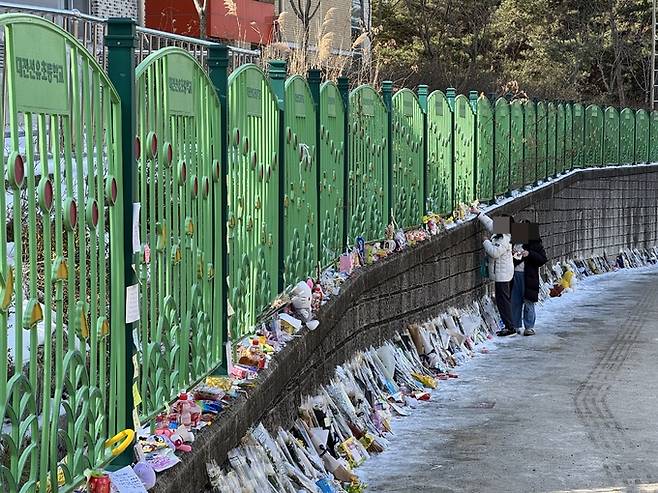 14일 오전 하늘양이 다니던 학교 앞에 시민들이 국화꽃과 과자, 장원영 포토카드, 추모메모 등을 남기며 애도하고 있다. 