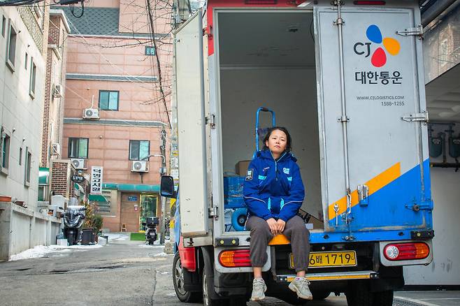 조유미 기자가 "퇴근 하고 싶다"는 생각을 하며 택배차 뒤에 앉아 있다. /김용재 영상미디어 기자