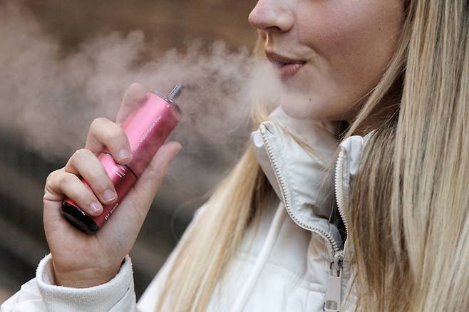 일회용 액상형 전자담배를 사용 중인 영국 여성 [사진 출처 = EPA 연합뉴스]
