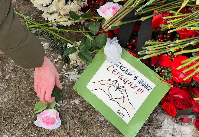 16일(현지시간) 러시아 모스크바 보리솝스코예 묘지에 있는 알렉세이 나발니의 묘지에서 시민들이 나발니 사망1주기를 추모하고 있다. ⓒ 로이터=뉴스1