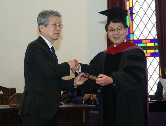 16일 일본 교토 도시샤대에서 열린 명예박사 학위 수여식에서 윤동주 시인의 조카 윤인석 성균관대 명예교수(왼쪽)와 고하라 가쓰히로 총장이 악수하고 있다. 사진 주오사카총영사관 제공
