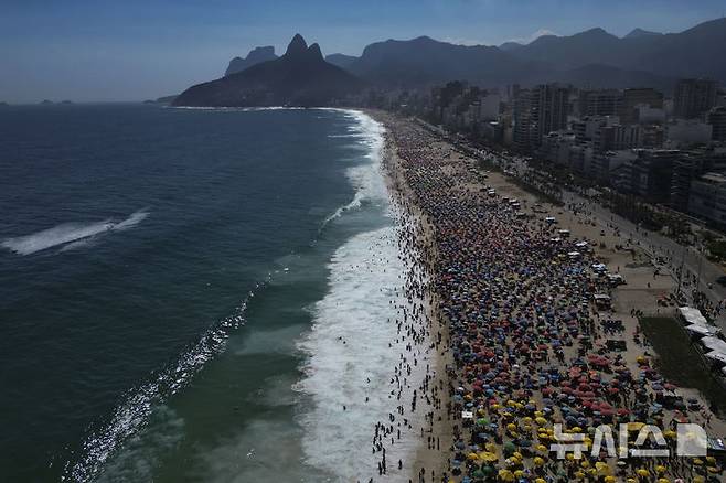 [리우데자네이루=AP/뉴시스] 16일(현지 시간) 브라질 리우데자네이루의 무더운 여름 날씨 속 피서객들이 피시나우 지 하무스 인공 해변에서 물놀이를 즐기고 있다. 2025.02.17.
