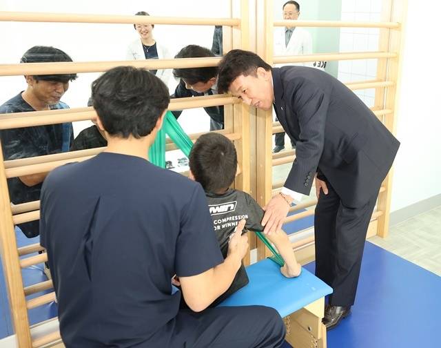 하나금융그룹은 지난 17일 서울 마포구 소재 푸르메재단 넥슨어린이재활병원에서 '장애 아동·청소년을 위한 재활 및 학습 보조기구 전달식'을 가졌다. 이날 전달식에 참석한 함영주 회장(사진 맨 오른쪽)이 중추신경계 발달치료를 받고 있는 장애 아동에게 따뜻한 격려의 말을 전하고 있다. /하나금융그룹