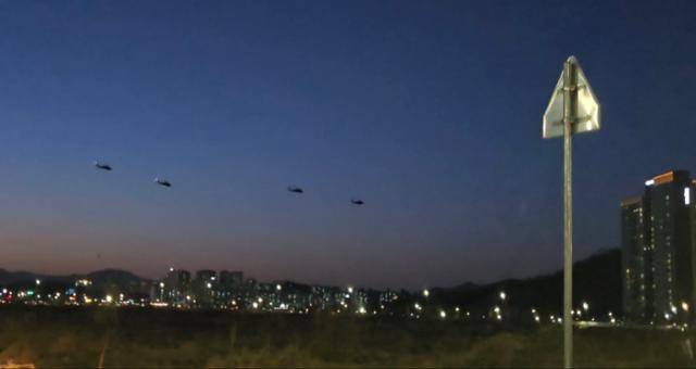 지난 13일 경기 의정부시 캠프 스탠리에서 급유를 마치고 이륙한 미군 헬기 4대가 어둑한 하늘을 배경으로 고산신도시 아파트 쪽으로 비행하고 있다. 임명수 기자