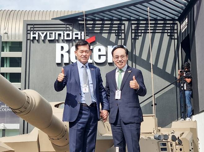 현대로템 대표이사 사장이 17일(현지시간) 아랍에미리트 아부다비에서 열린 국제방산전시회(IDEX2025)에서 중동형 K2 전차를 배경으로 기념촬영을 하고 있다.