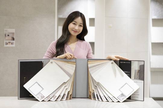 모델이 kcc글라스 홈씨씨 인테리어의 '숲 휴가온' 바닥재를 소개하고 있다.  [KCC글라스 제공]