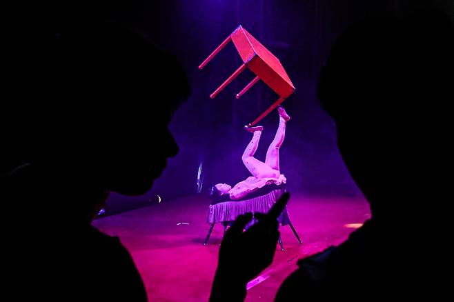 곡예사들이 동료의 묘기를 바라보며 대화를 나누고 있다.