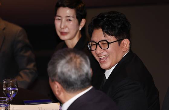 Bang Si-hyuk, chairman of K-pop powerhouse HYBE, talk with other attendants at the 64th general meeting of The Federation of Korean Industries (FKI) at the FKI Tower conference center in western Seoul on Feb. 20. [YONHAP]