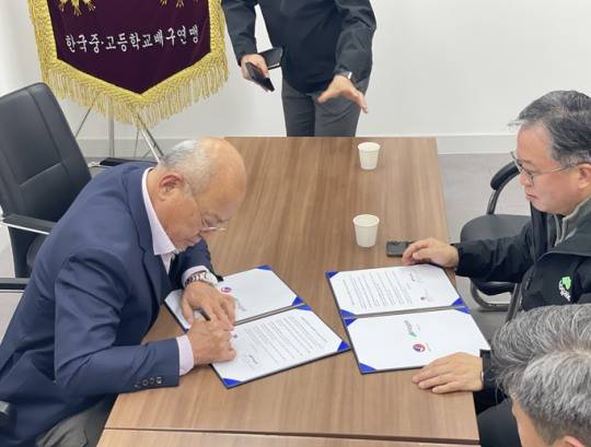 한국중고배구연맹 김홍 회장(왼쪽)이 호각과의 MOU 계약서에 서명하고 있다. {한국중고배구연맹 제공]