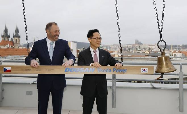 박상현(오른쪽) 두산에너빌리티 사장과 페트르 코블리츠 프라하 증권거래소 CEO가 증시 상장을 알리는 종을 울리고 있다. [두산에너빌리티 제공]