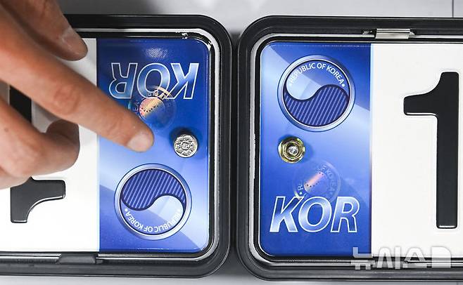 [수원=뉴시스] 김종택 기자 = 자동차 등록번호판 봉인제도 폐지를 하루 앞둔 20일 경기도 수원도시공사 번호판제작소에서 관계자가 기존 스테인리스 마개로 봉인된 번호판(사진 왼쪽)과 마개를 제거한 뒤 너트로 고정한 번호판을 보여주고 있다.도난, 번호판 위·변조 방지를 위해 1962년 시행된 자동차 등록번호판 봉인제도는 자동차관리법 일부 개정에 따라 등록번호판에 봉인을 부착하지 않고 운행할 수 있다. (공동취재) 2025.02.20. photo@newsis.com