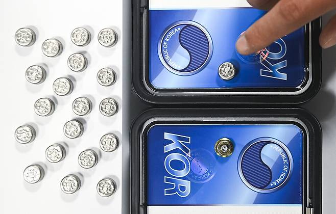 자동차 등록번호판 봉인제도 폐지를 하루 앞둔 20일 경기 수원도시공사 수원시번호판제작소에서 관계자가 기존 스테인리스 마개로 봉인된 번호판(위쪽)과 마개를 제거한 뒤 너트로 고정한 번호판을 보여주고 있다. ⓒ연합뉴스