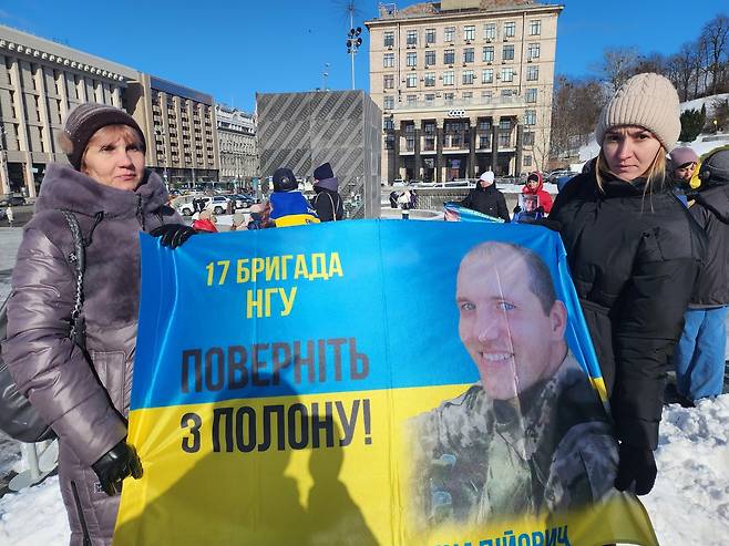 아들 생환 기다리는 모정 (키이우=연합뉴스) 신창용 특파원 = 20일(현지시간) 우크라이나 수도 키이우의 독립광장에서 스비틀라나 씨(왼쪽)가 아들의 무사귀환을 기원하며 펼침막을 들고 있다. 오른쪽은 아들의 여자친구. 2025.02.20 changyong@yna.co.kr