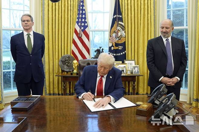 [워싱턴=AP/뉴시스]도널드 트럼프 미국 대통령이 3일(현지시각) 미 워싱턴 백악관 오벌오피스에서 재무부 장관 스콧 베센트(왼쪽)와 상무부 장관 하워드 러트닉이 지켜보는 가운데 행정 명령에 서명하는 모습.
