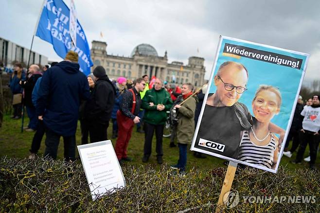 프리드리히 메르츠 CDU 대표와 알리스 바이델 AfD 공동대표(손팻말 안) [AFP 연합뉴스 자료사진. 재판매 및 DB 금지]