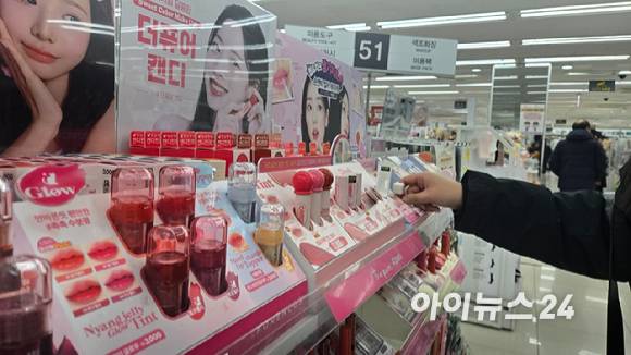 22일 서울의 다이소 매장에서 한 소비자가 화장품을 고르고 있다.  [사진=진광찬 기자]