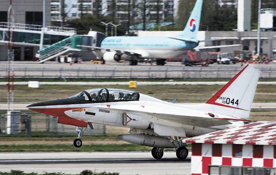 A military airplane lands at Gwangju Airport in April last year. A passenger airplane is seen behind the military aircraft. [YONHAP]