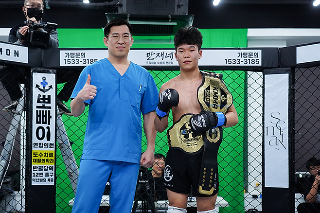 KMMA 플라이급 챔피언 이영웅(오른쪽)이 밴텀급 타이틀까지 석권한 후 메인스폰서 뽀빠이연합의원 김성배 대표원장과 기념 촬영을 하고 있다. 사진=스탠다드앤드프로그레스 스포츠에이전시 제공