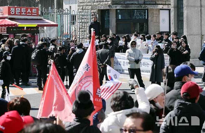 [부산=뉴시스] 하경민 기자 = 윤석열 즉각 파면을 바라는 부산대학교 학생 30여 명(사진 위)이 24일 부산 금정구 부산대 정문 앞에서 윤석열 대통령 탄핵반대 시국선언을 규탄하는 기자회견을 열고 있는 가운데 도로 맞은편에서 보수단체 회원들이 맞불 구호를 외치고 있다. 2025.02.24. yulnetphoto@newsis.com