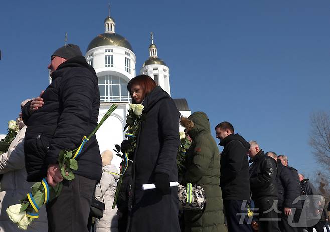 24일 우크라이나 키예프 외곽 부차의 러시아의 우크라이나 침공 3주년을 맞아 시민들이 집단 묘지에서 추모식에 참여하고 있다. ⓒ 로이터=뉴스1