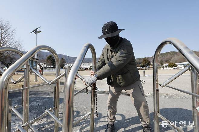 전남 보성군의 한 초등학교 입구 철문을 관계자가 걸어 잠그고 있다. 이 초등학교는 3월 1일 폐교할 예정이다. 보성=박영철 기자 skyblue@donga.com