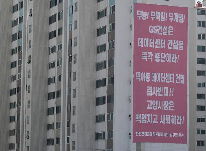경기 고양시 일산서구 덕이동 데이터센터 공사현장 뒤편 아파트에 착공을 취소하라는 현수막이 걸려 있다. [이충우 기자]