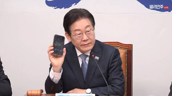 이재명 더불어민주당 대표가 26일 서울 여의도 국회에서 열린 최고위원회의에서 휴대전화 사진을 보여주고 있다 (사진=민주당 유튜브 채널 ‘델리민주’ 영상 캡처)